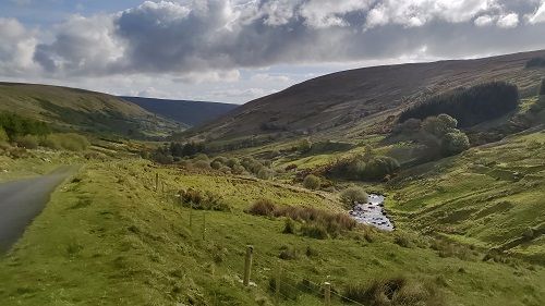 Valley with stream running through and grass hills on either side