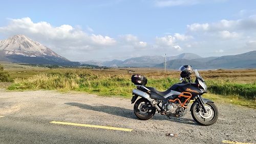 Suzuki Vstrom motorcycle with Errigal Mountain and smaller hills in the background