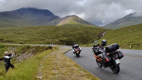 Two biles parked in a layby with mountains in background