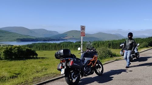 Suzuki Vstrom motorcyle with lake and mountains in background